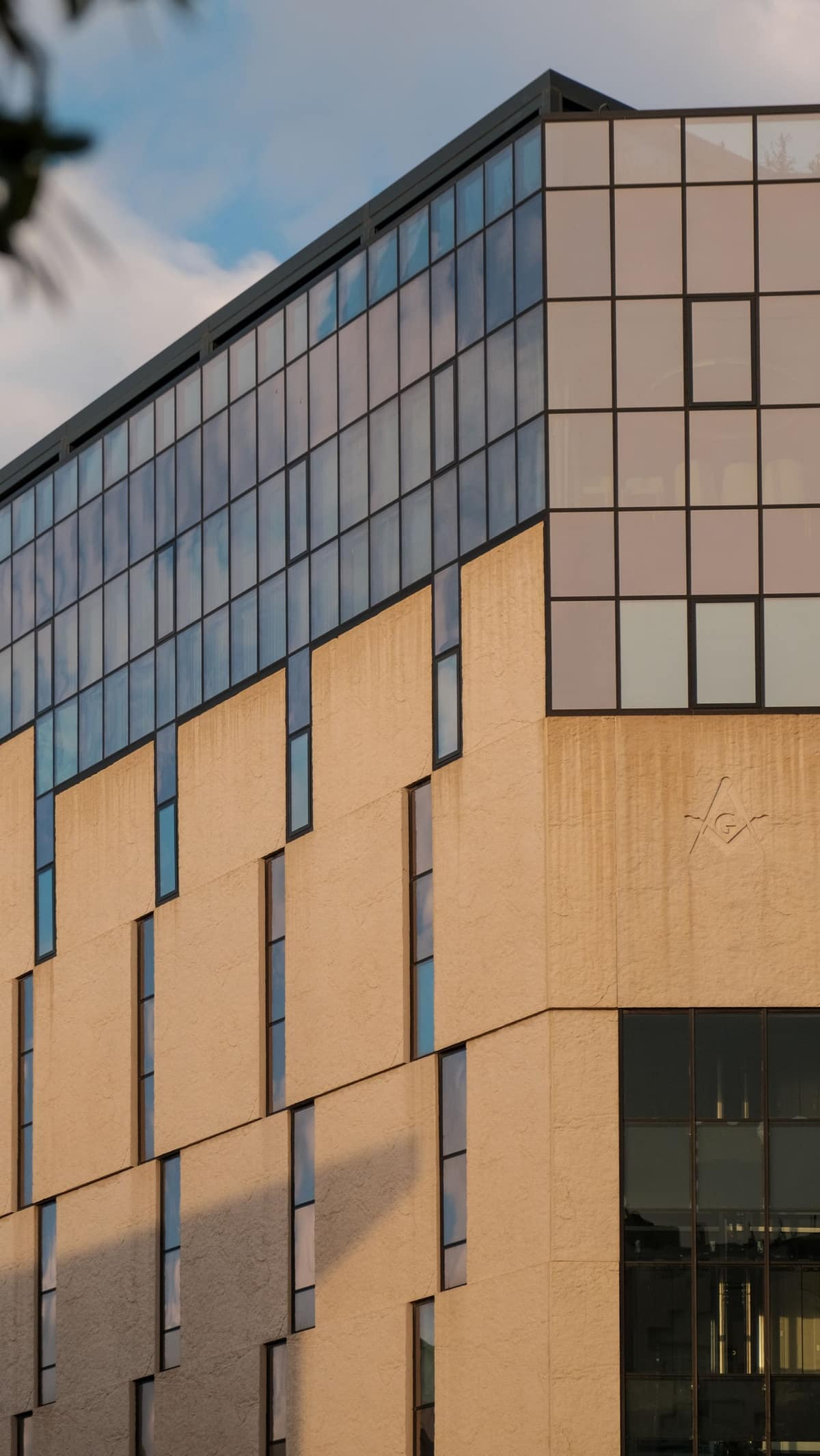 The tan panel and glass facade of a modern civic building