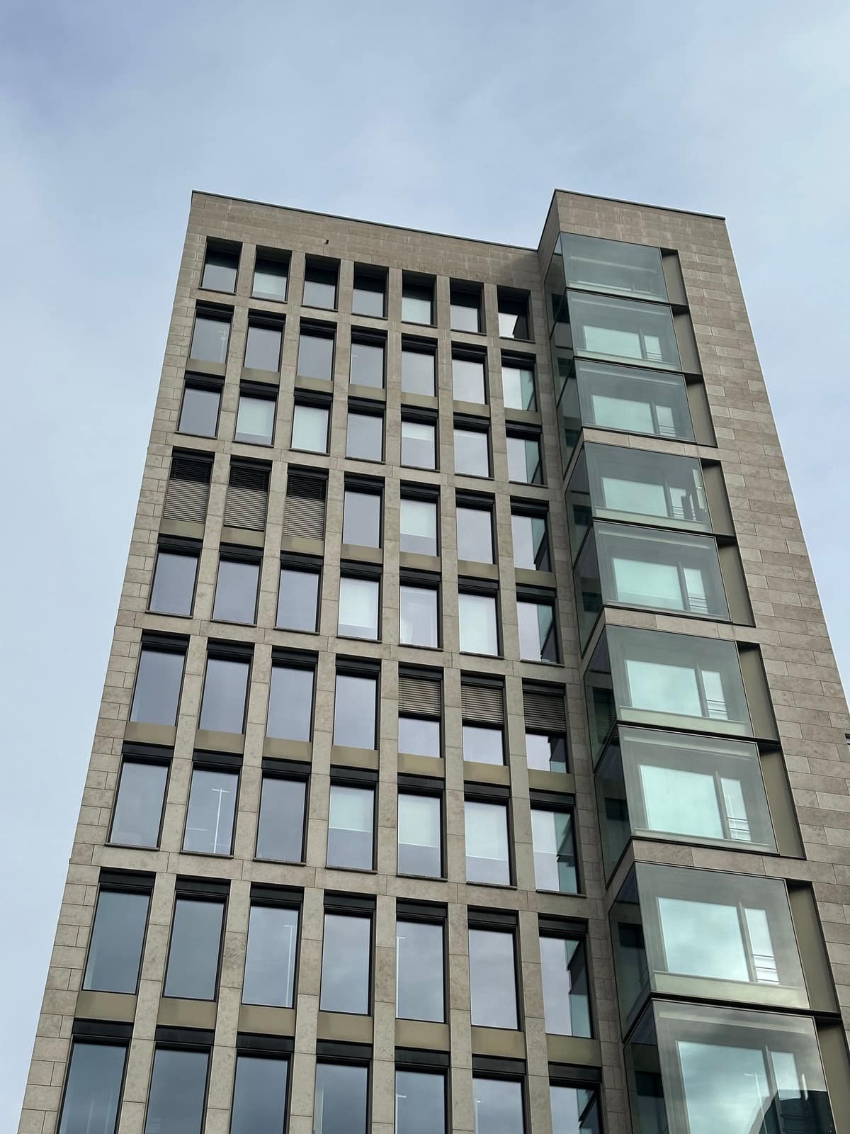A mid-rise concrete and window building seen from below